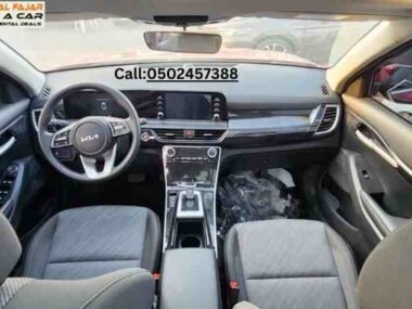 Front seat view of Kia Seltos 2024 red rent a car in Dubai